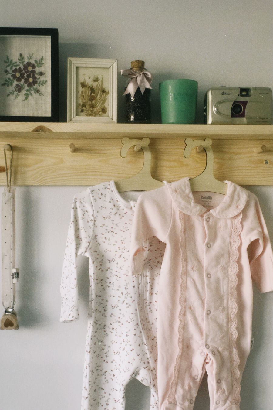 Pale printed baby footies hanging on hooks
