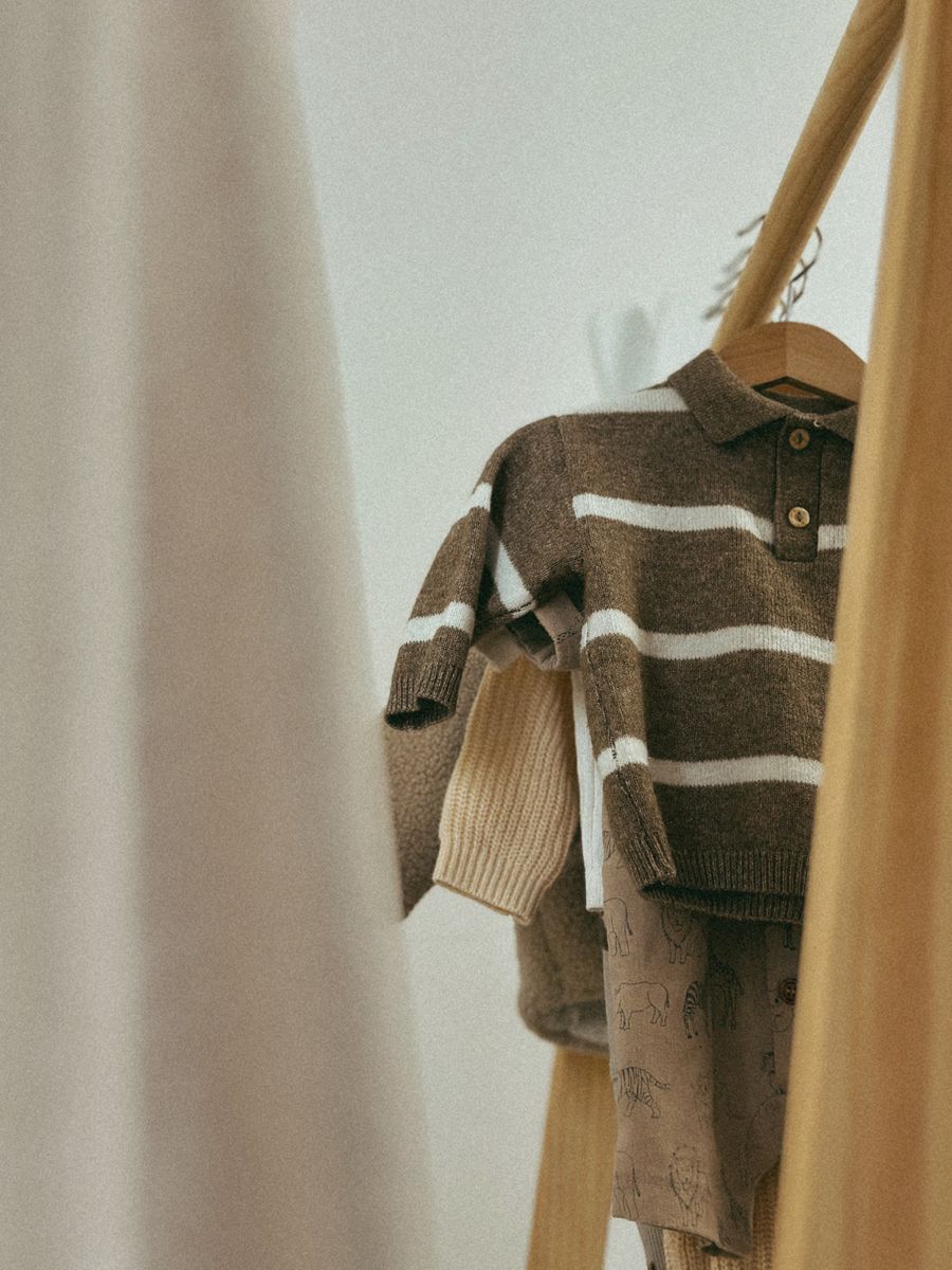 Brown and cream striped knit sweater on a hanger